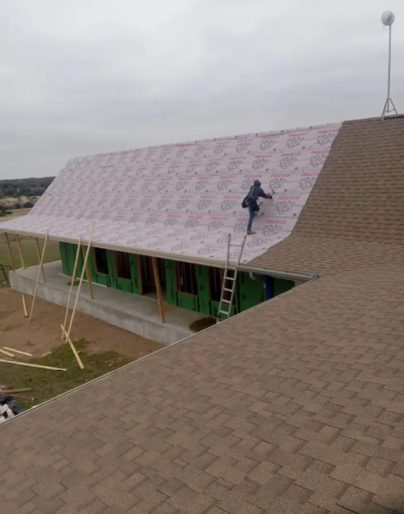 Worker preparing underlayment for a metal roof installation in Flossmoor
